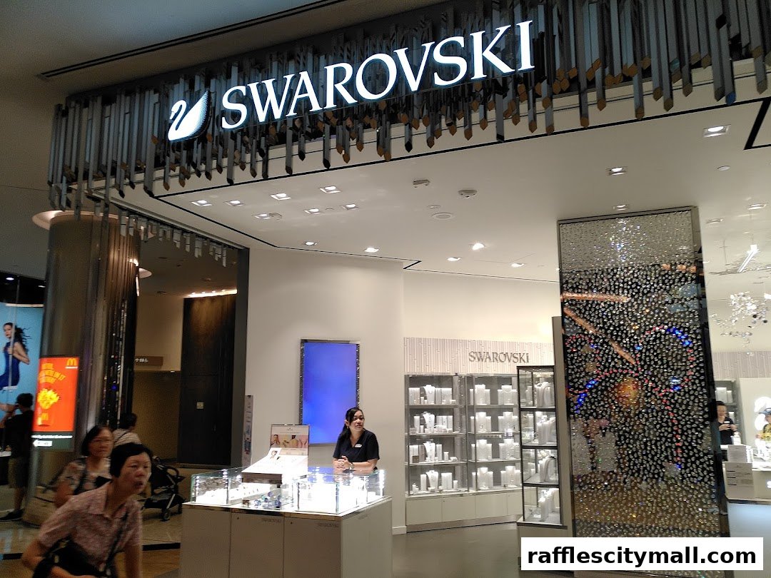 The entrance of a Swarovski store with illuminated signage and display cases.