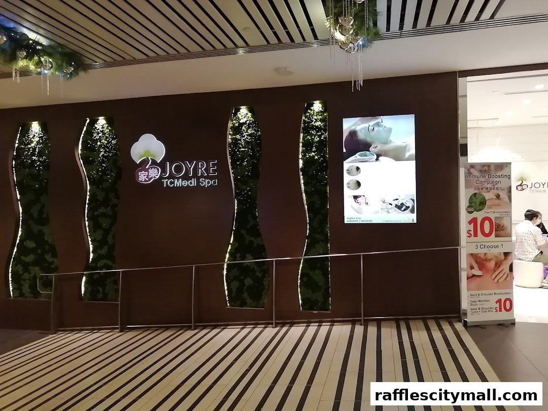 The entrance of JOYRE TCMedi Spa with decorative green pillars and promotional posters.