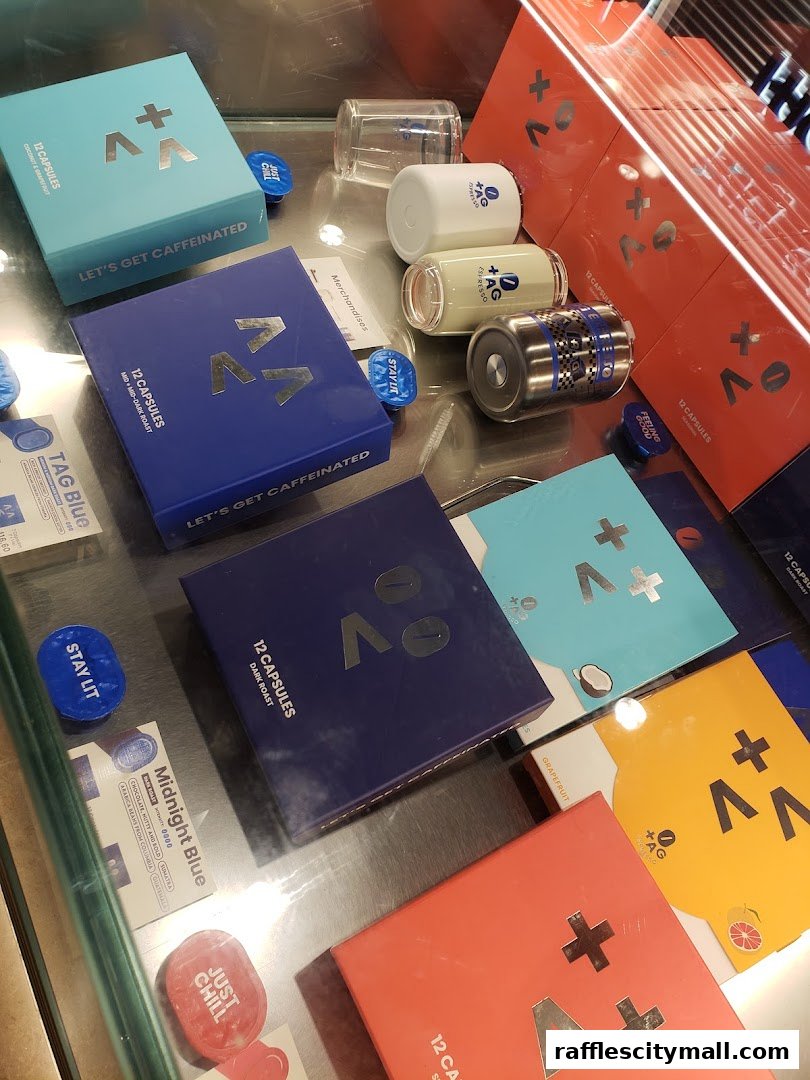 A display of colorful coffee capsule boxes and branded cups from TAG Espresso.