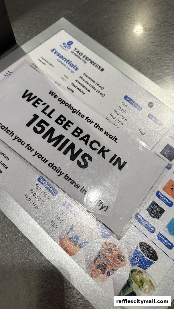 A menu from TAG Espresso at Raffles City with a sign indicating a 15-minute wait.