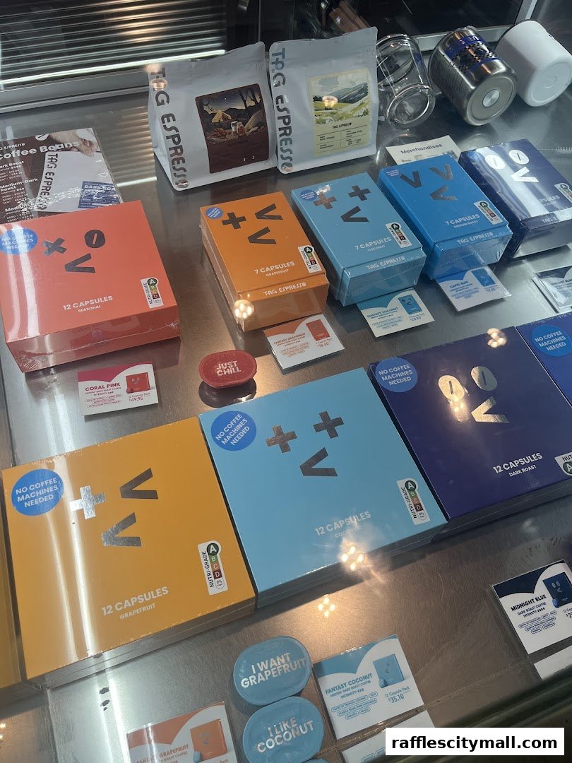 A display of TAG Espresso coffee capsules and coffee beans in various flavors.