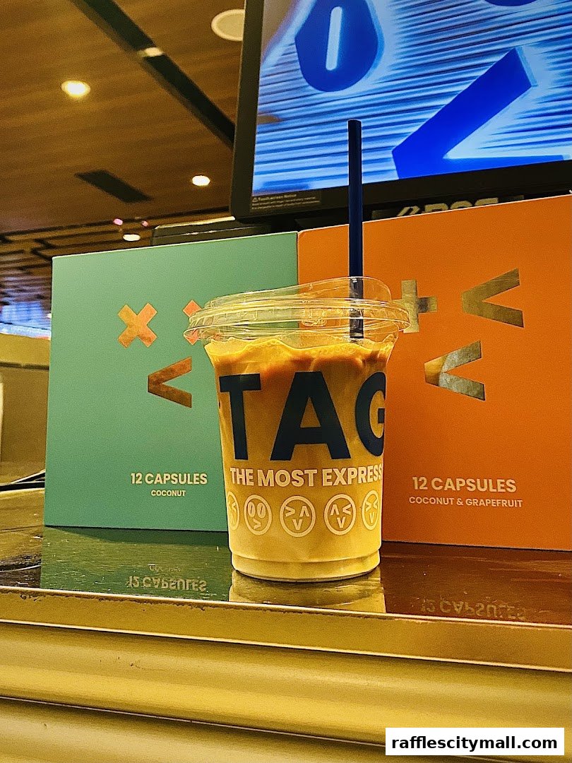 A cup of iced coffee from TAG Espresso with branded boxes in the background.