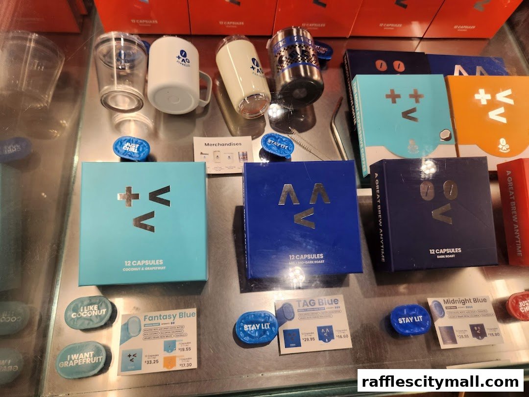 A display of TAG Espresso coffee capsules and merchandise, including cups and branded items.