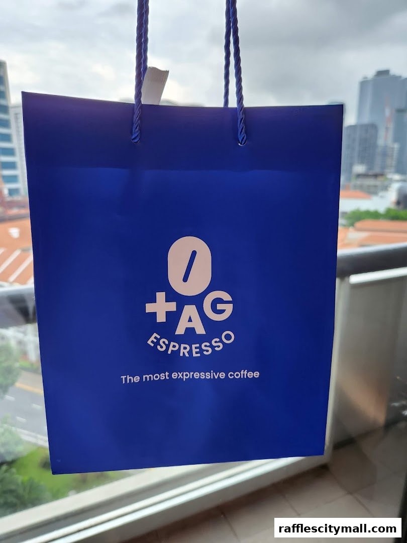 A blue shopping bag with the TAG Espresso logo and slogan.