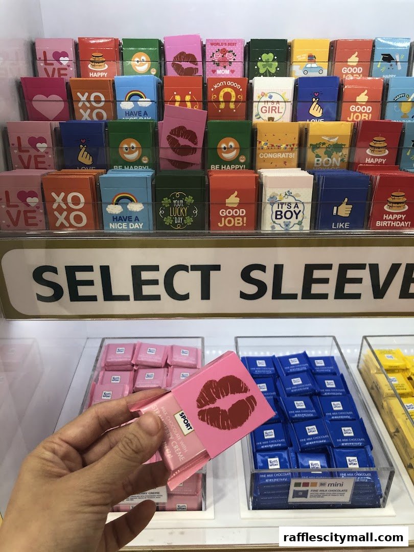 A display of colorful chocolate bars with various greetings and designs, including a hand holding one.