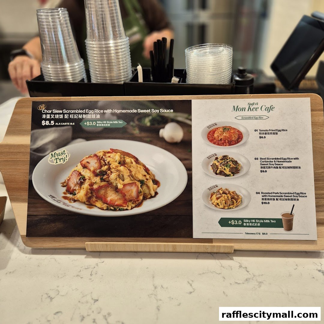 A menu board displays various scrambled egg rice dishes and a milk tea offer from Mon Kee Cafe.