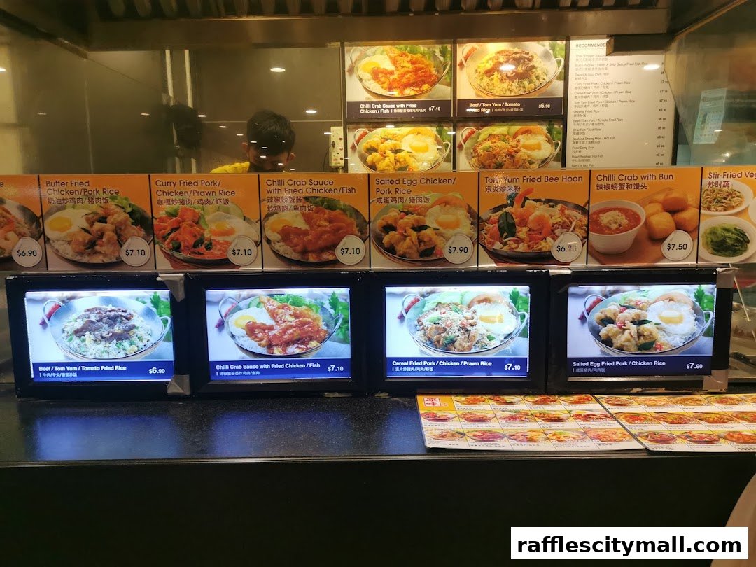 A food stall display with various dishes and prices shown on screens and posters.