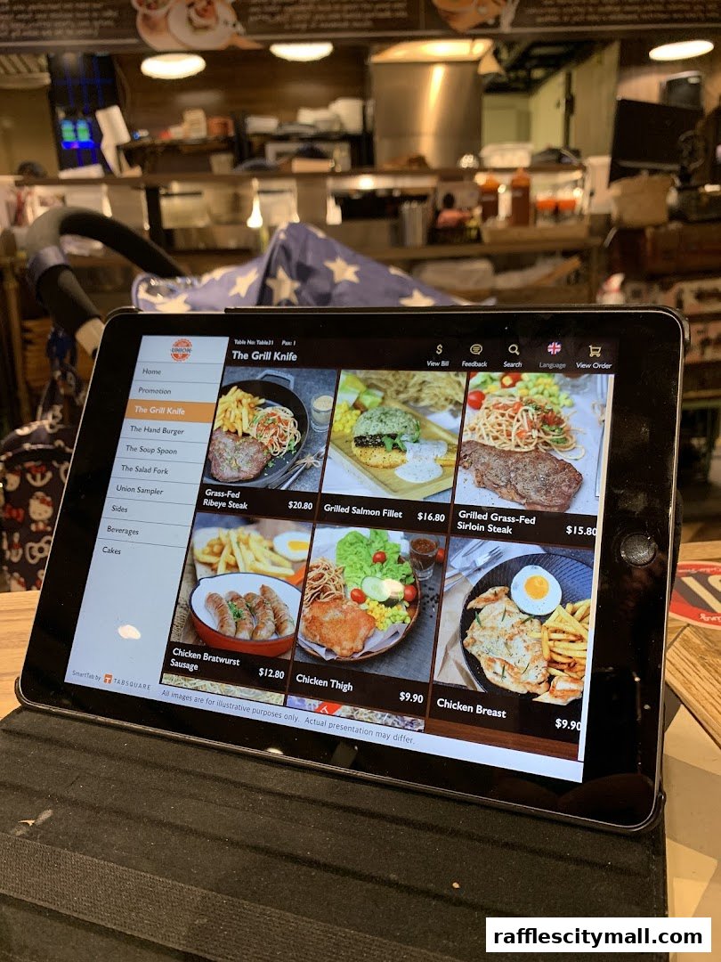 A tablet displays a digital menu with various grilled dishes and their prices.