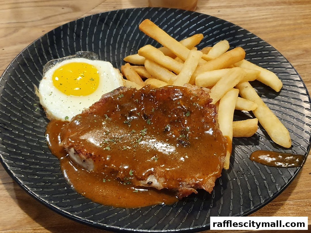 A hearty meal of steak, fries, and a sunny-side-up egg with gravy.
