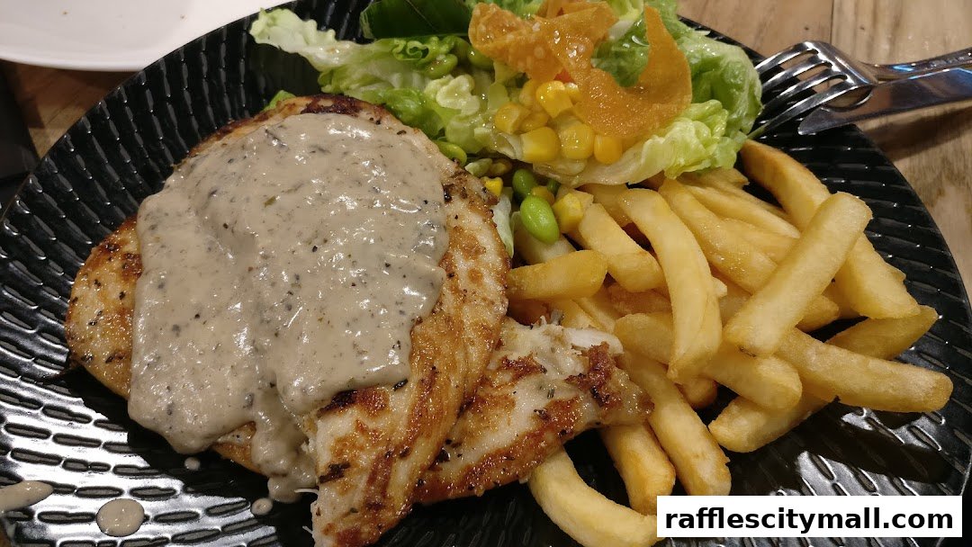 A close-up of a grilled chicken dish with creamy mushroom sauce, fries, and a side salad.