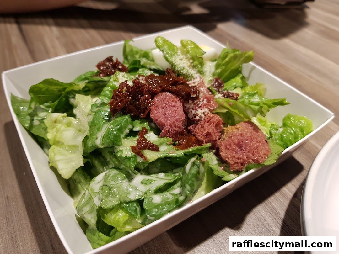 A close-up shot of a fresh salad with lettuce, croutons, and sun-dried tomatoes.