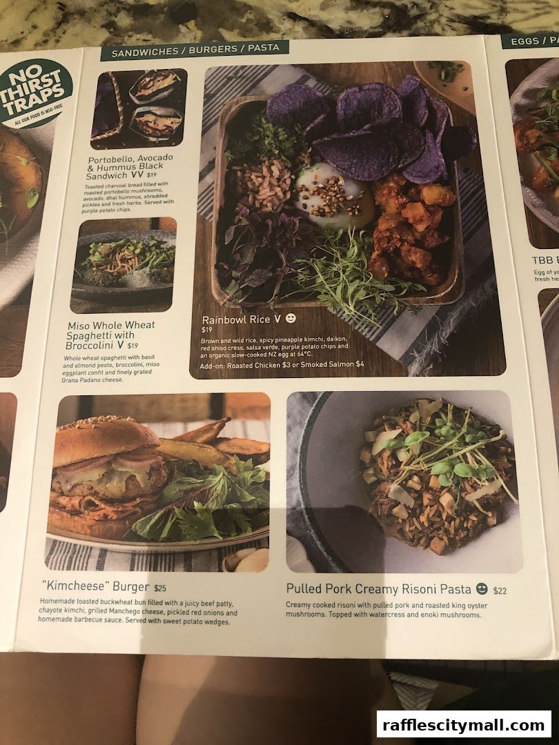 A menu from Tiong Bahru Bakery featuring sandwiches, burgers, pasta, and rice bowls.