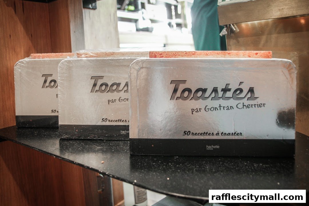 Three packaged books titled 'Toastés par Gontran Cherrier' are displayed on a shelf.