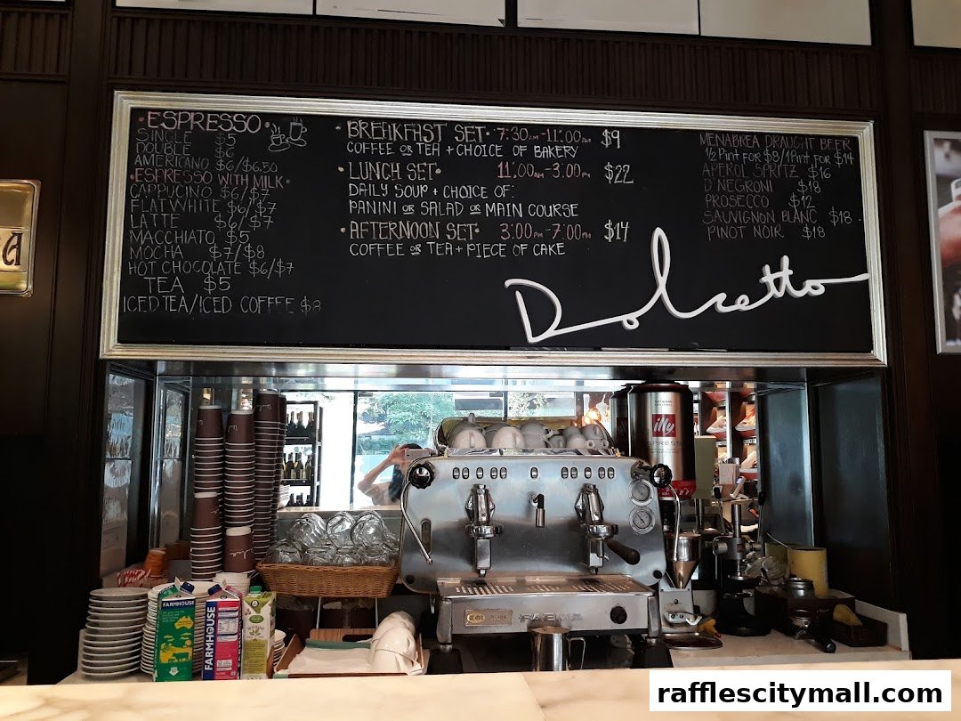 A chalkboard menu displays espresso drinks, sets, and alcoholic beverages above a coffee machine.