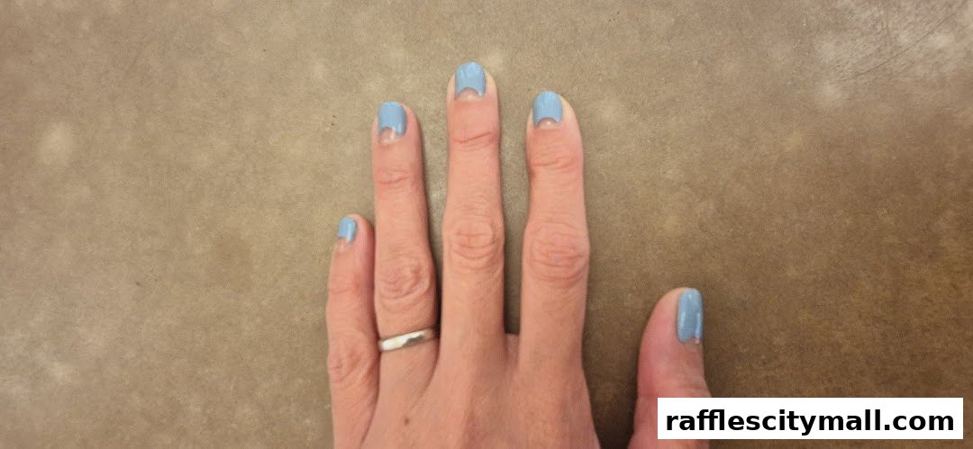 A hand with light blue nail polish, some chipped, against a brown background.