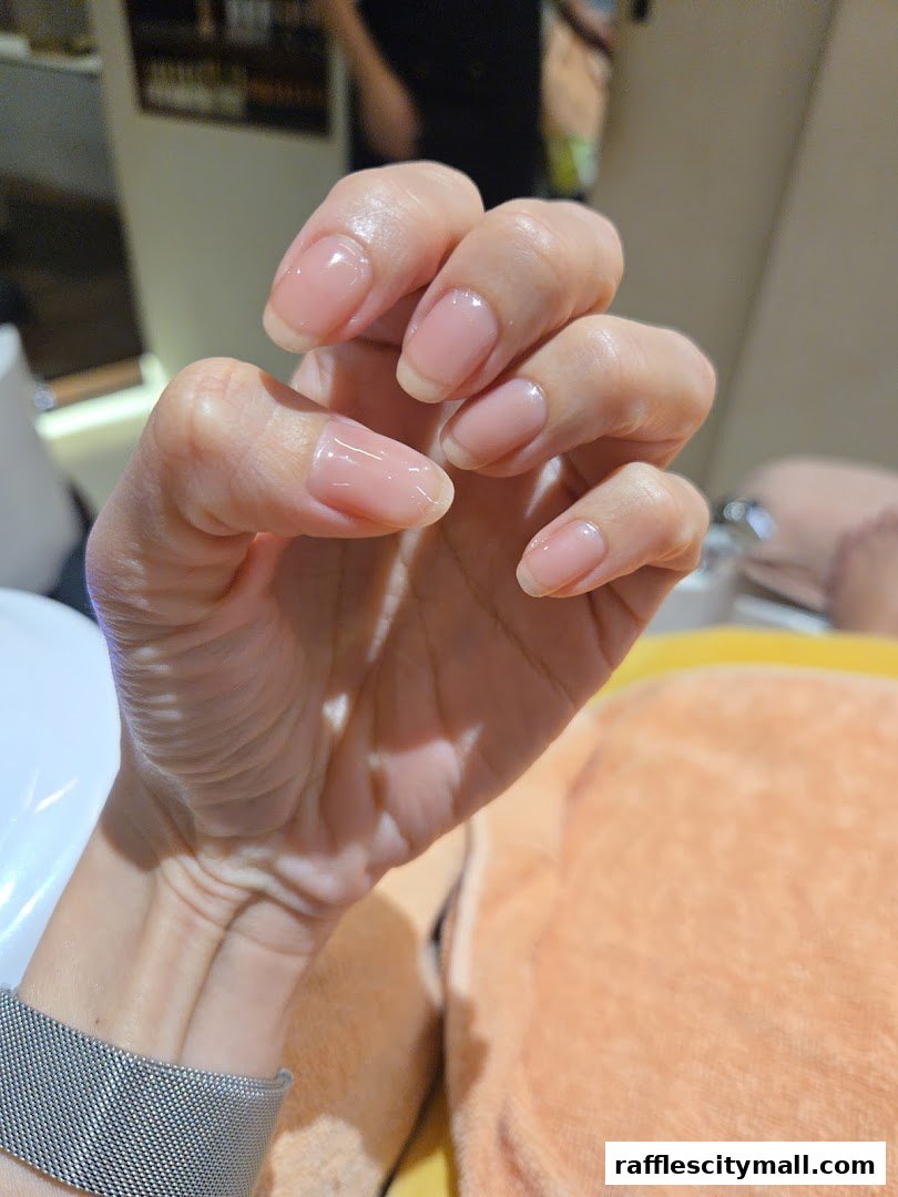 A close-up of a person's hands with perfectly manicured, natural-looking nails.