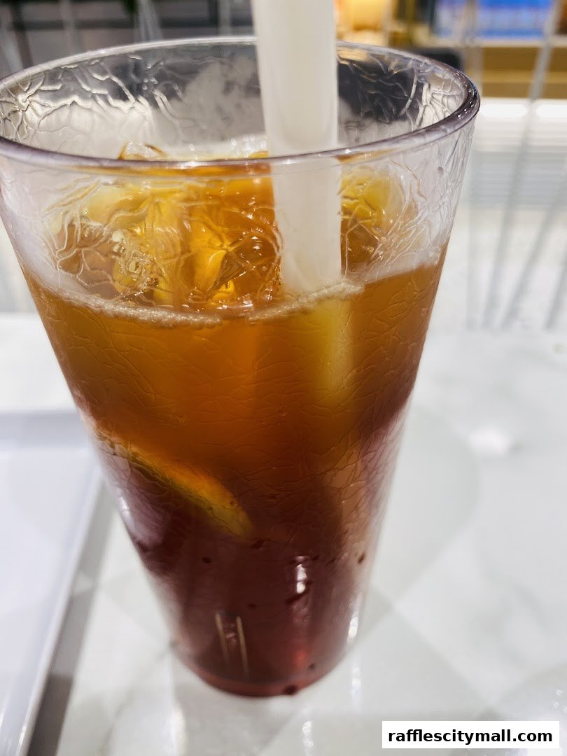 A close-up shot of a refreshing iced tea with ice cubes and a straw.