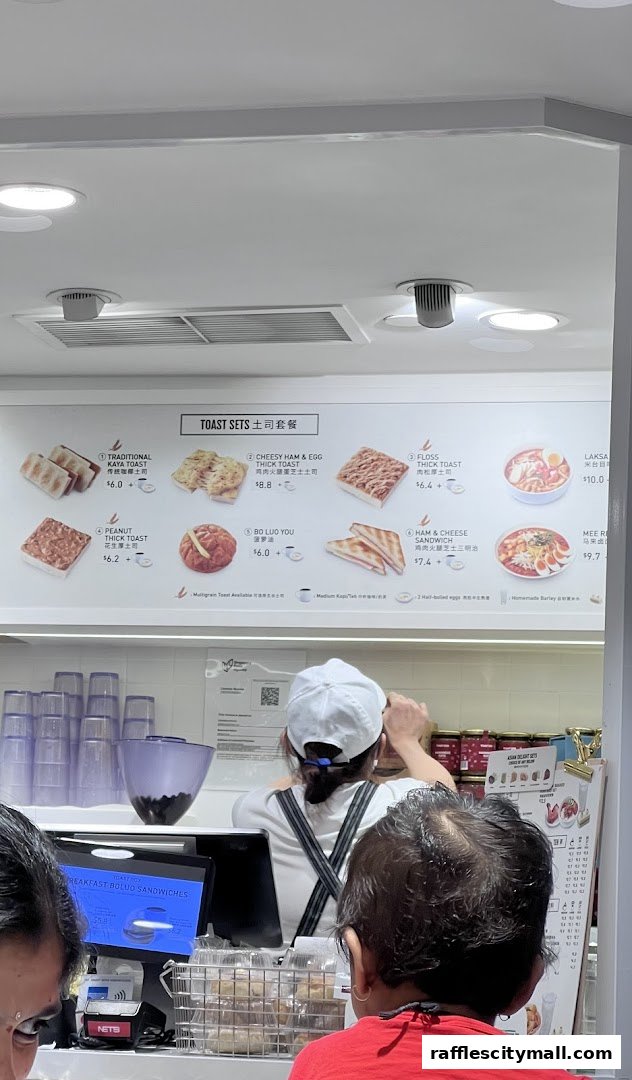 A menu board displaying various toast sets and other food items with prices.