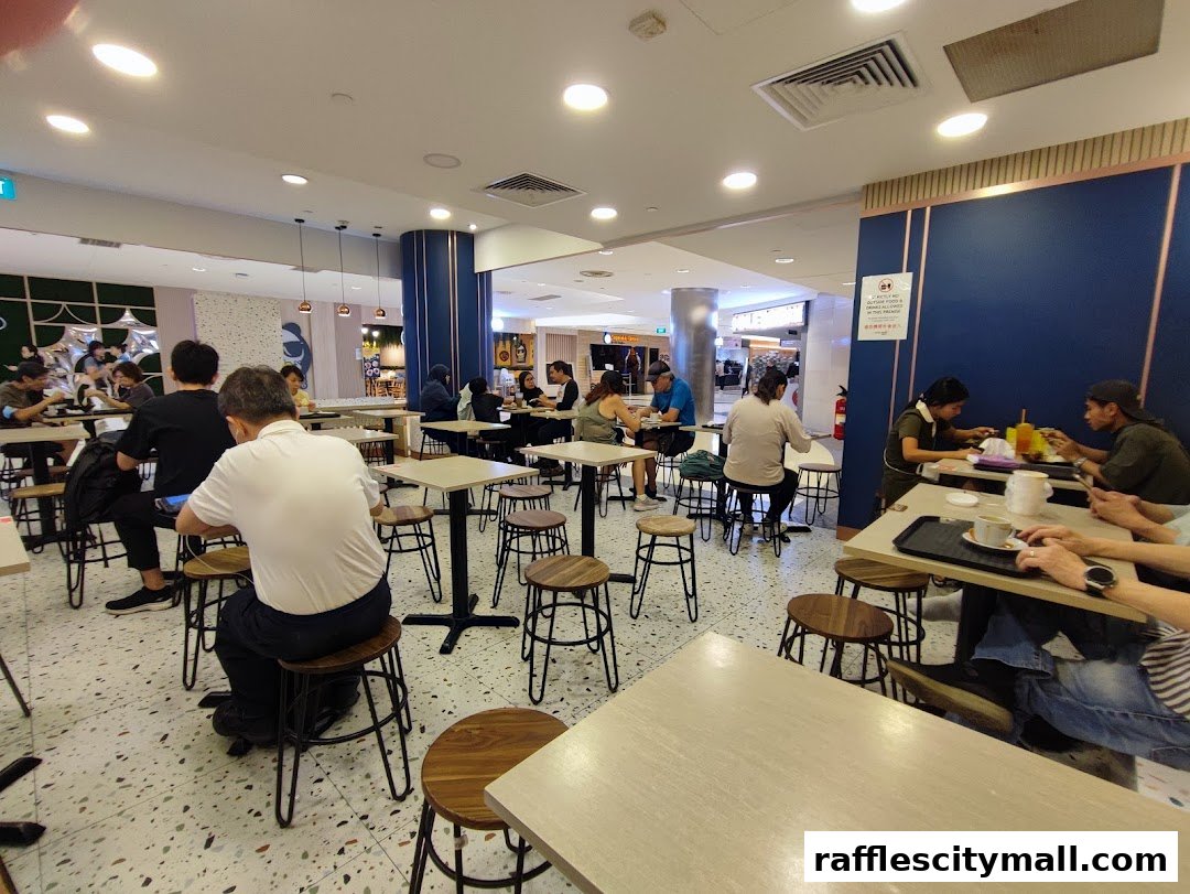 People dining at tables inside a bright, modern food court with blue accents.