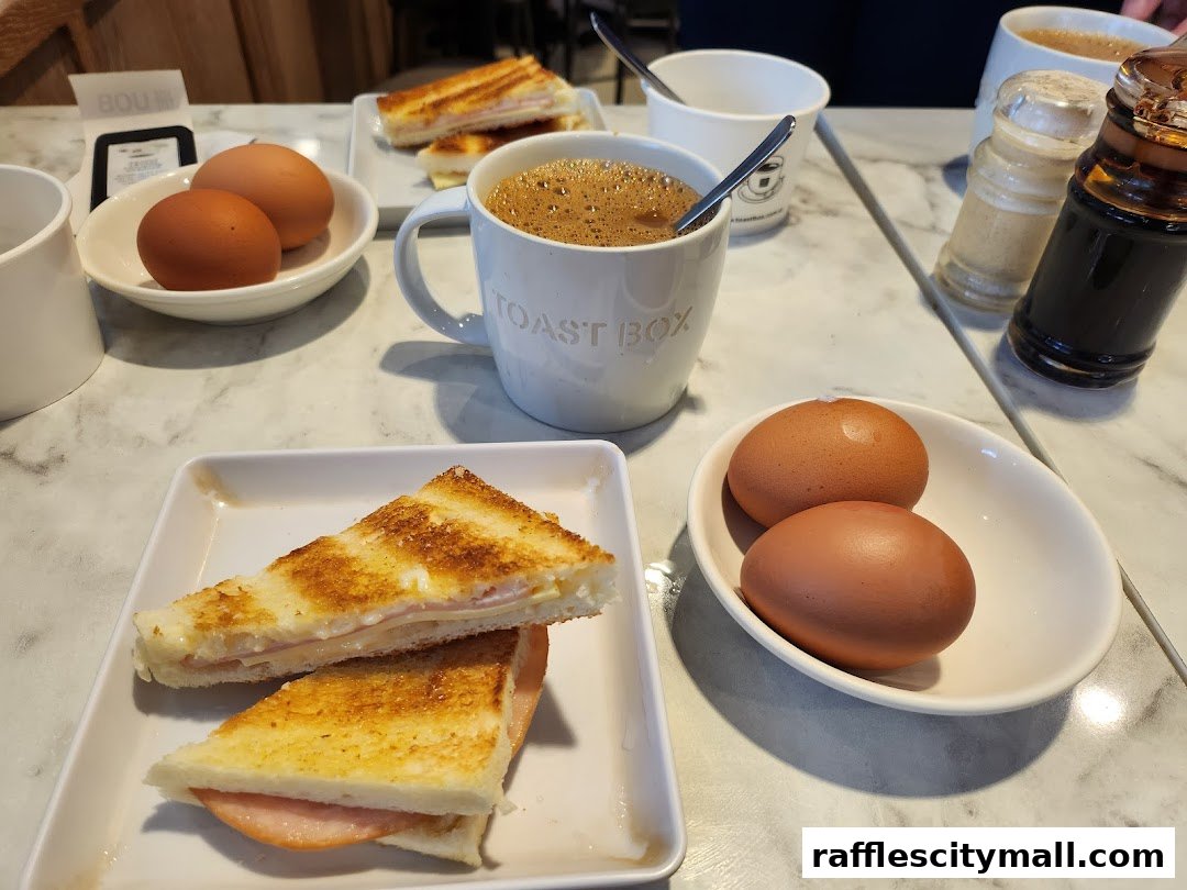 A table setting at Toast Box with coffee, toast, and boiled eggs.