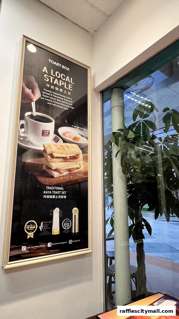 A framed poster showcasing Toast Box's traditional Kaya Toast Set with coffee and eggs.