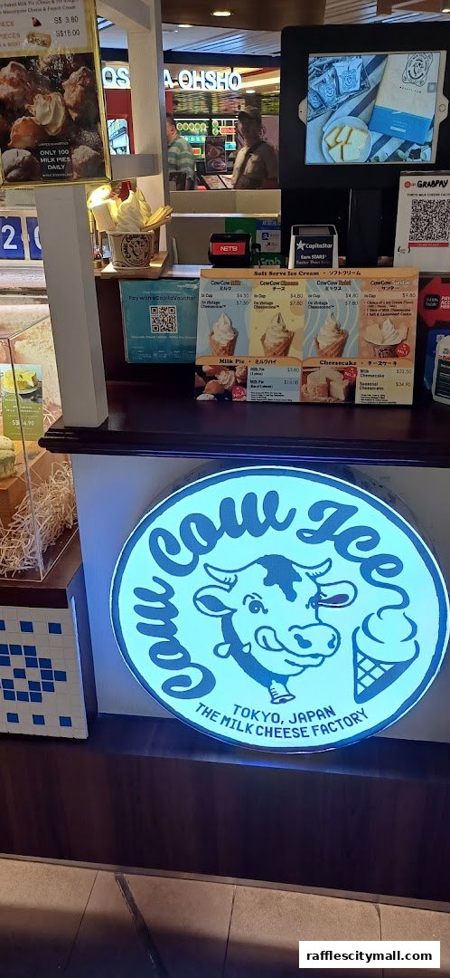 A brightly lit counter display for Tokyo Milk Cheese Factory, featuring soft serve ice cream and milk pies.