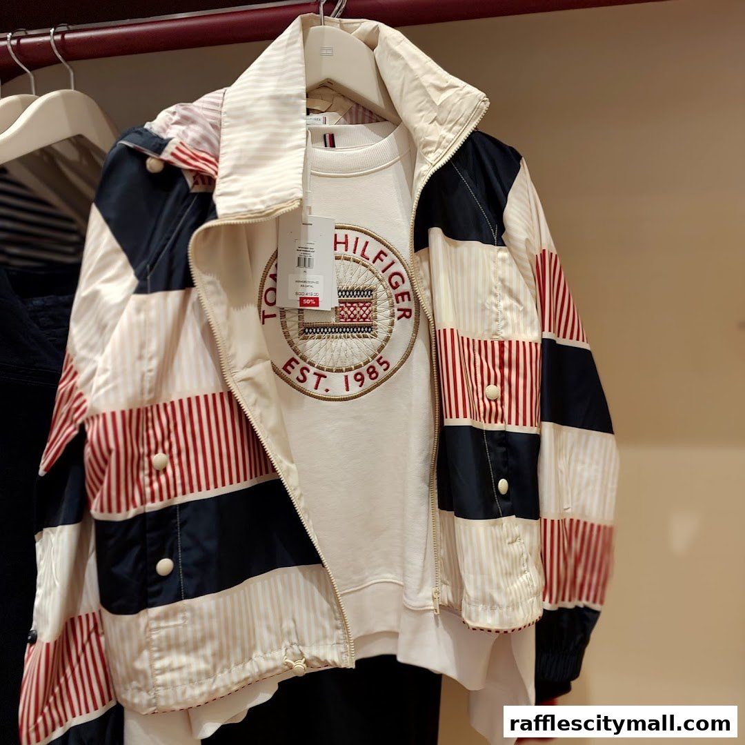 A Tommy Hilfiger jacket and sweatshirt with the brand's logo are displayed on hangers.