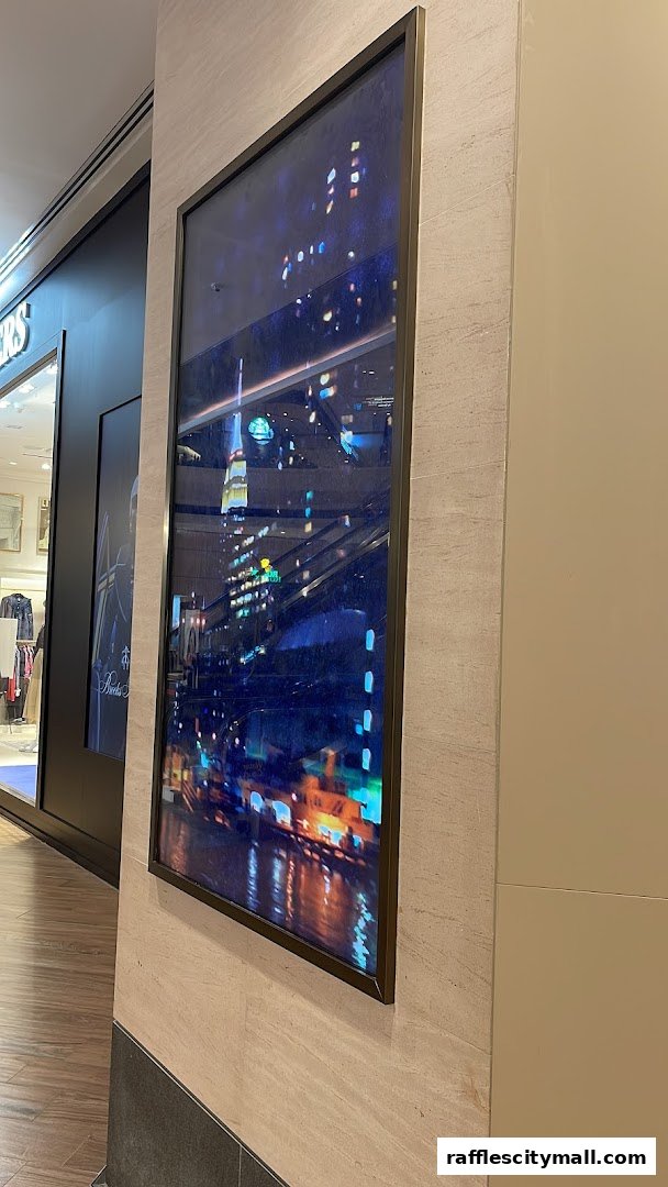 A framed artwork depicting a vibrant city skyline at night with reflections.