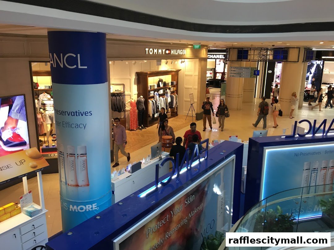 A view of the Tommy Hilfiger store and other shops in a mall, with shoppers walking around.