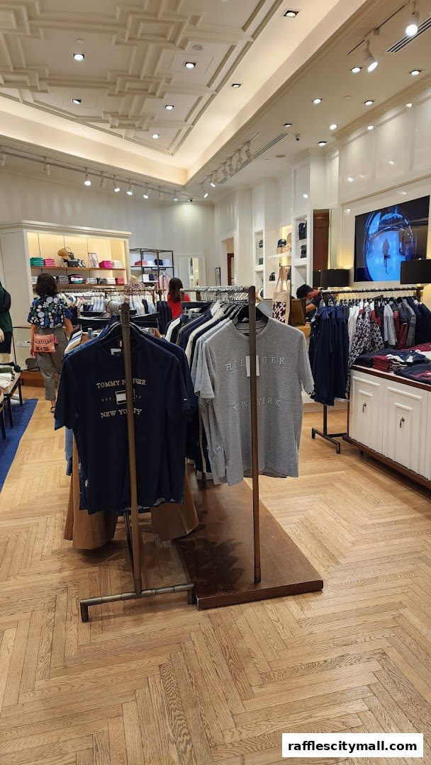 Interior view of a Tommy Hilfiger store showcasing t-shirts and apparel on racks.