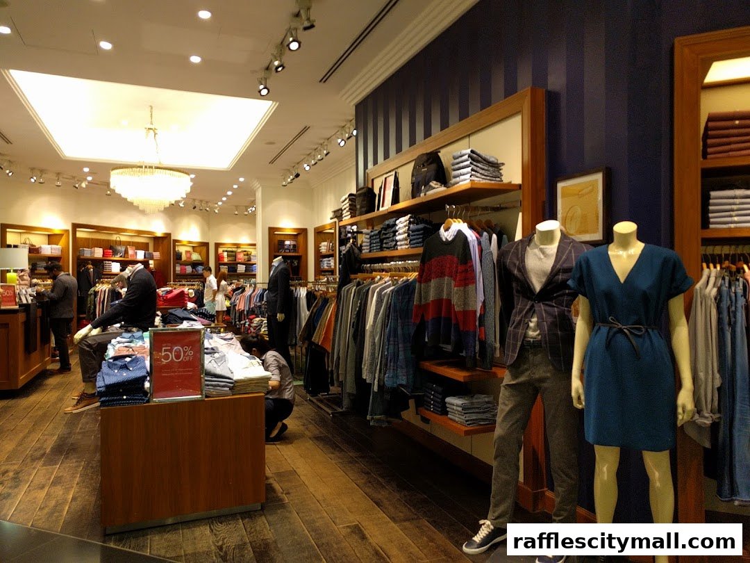 Interior view of a Tommy Hilfiger store showcasing clothing on mannequins and racks.