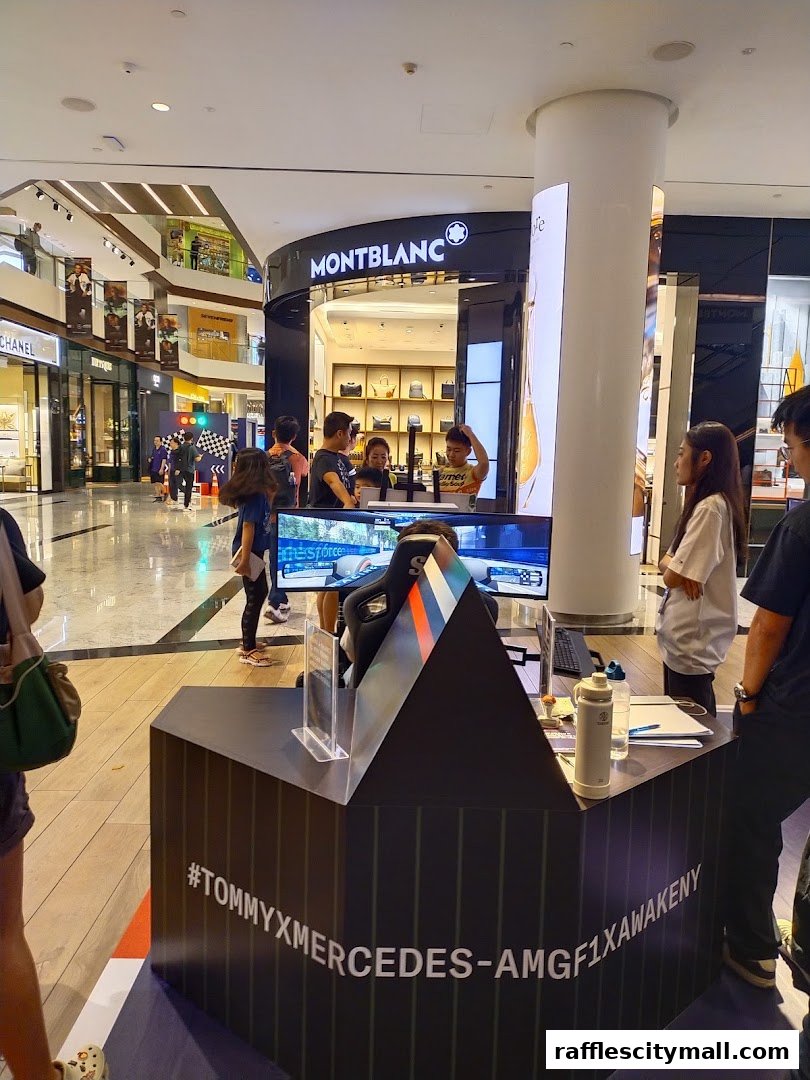 People gather around a gaming setup with a Tommy Hilfiger and Mercedes-AMG F1 collaboration display.