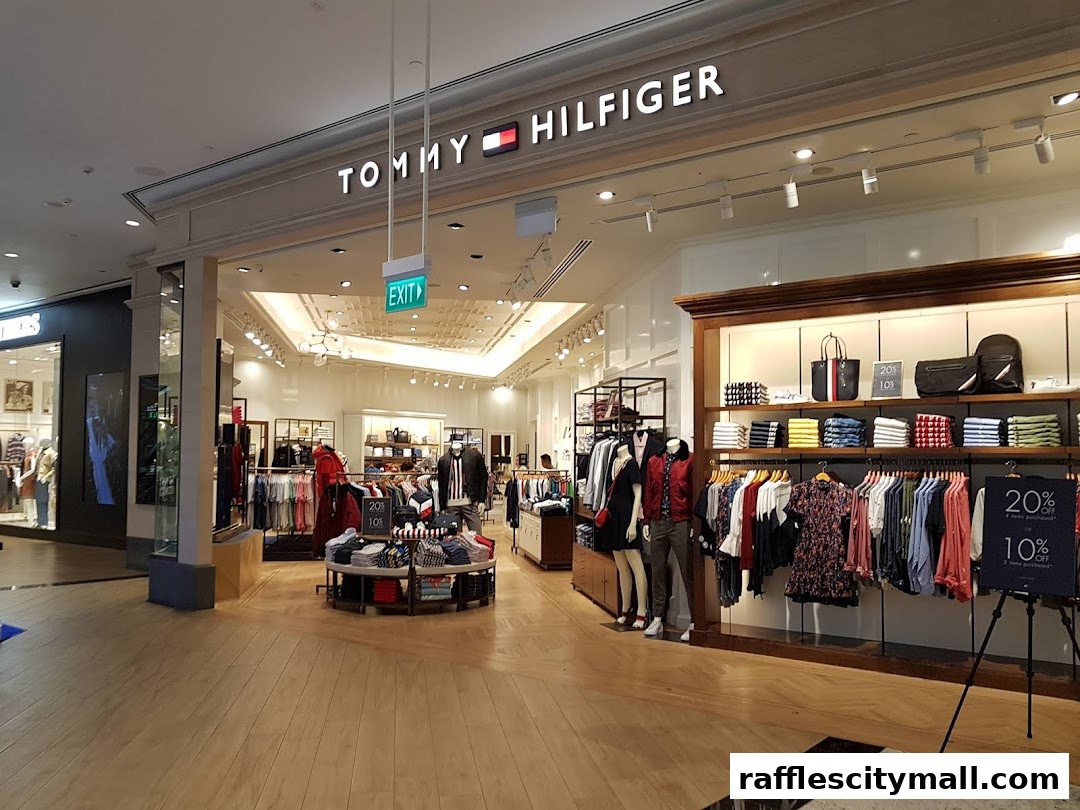The entrance of a Tommy Hilfiger store showcasing clothing and accessories with sale signs.
