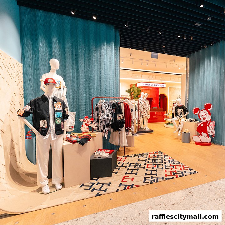 A Tommy Hilfiger store display featuring mannequins dressed in casual wear and Mickey Mouse themed apparel.