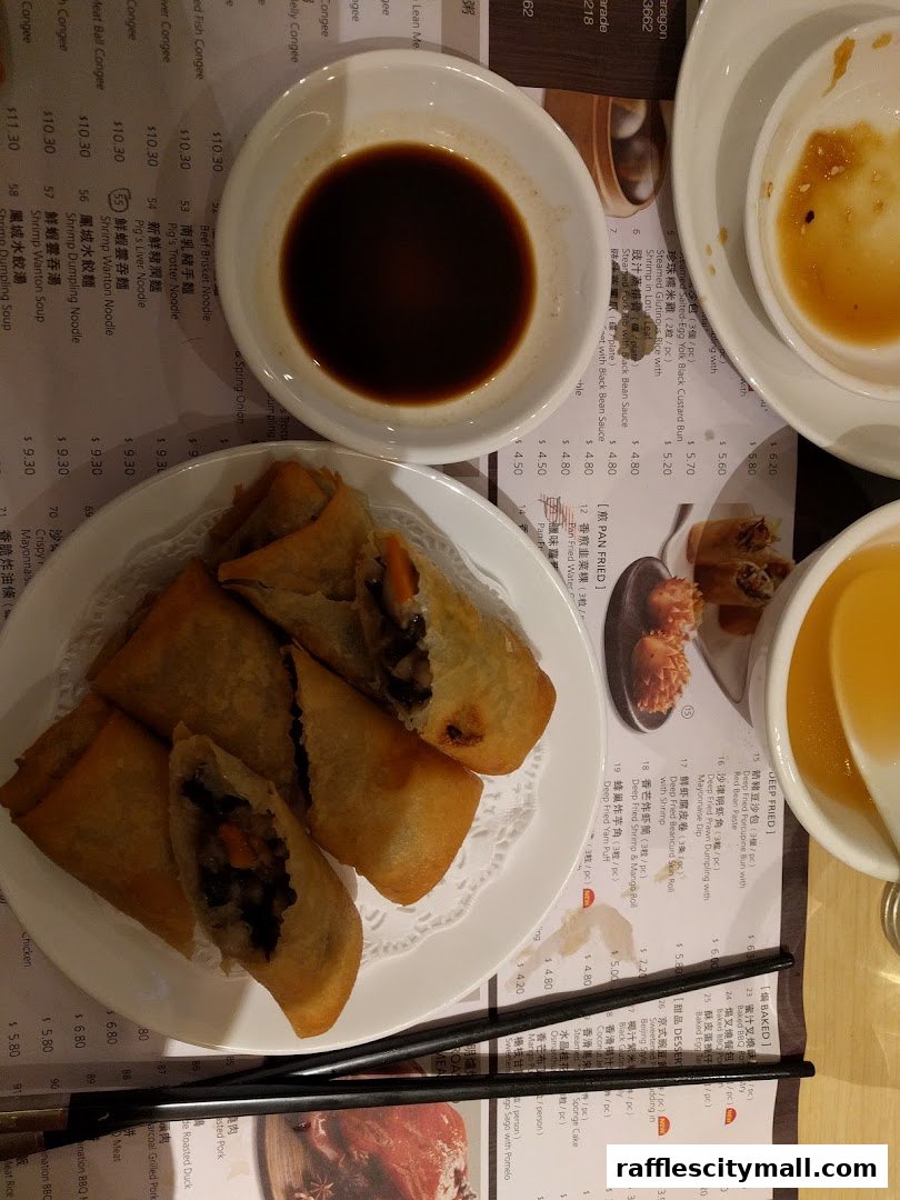 A table setting with dim sum dishes, soy sauce, and a menu.