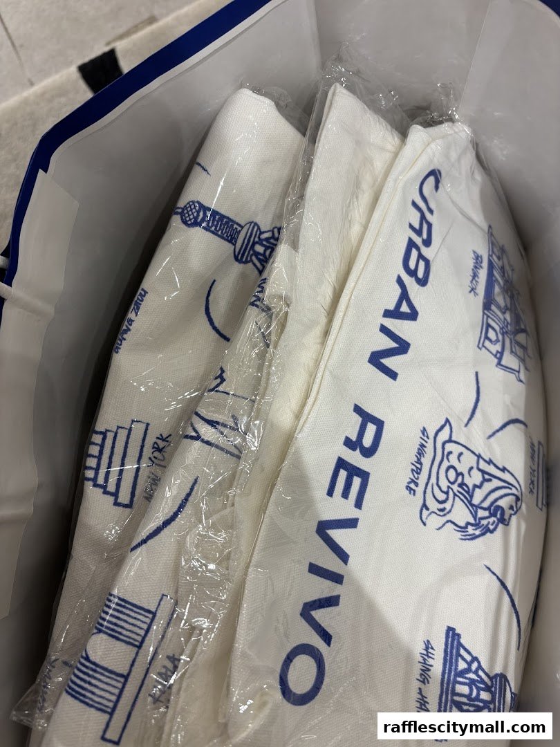 A shopping bag from URBAN REVIVO containing individually wrapped items with city landmarks printed on them.