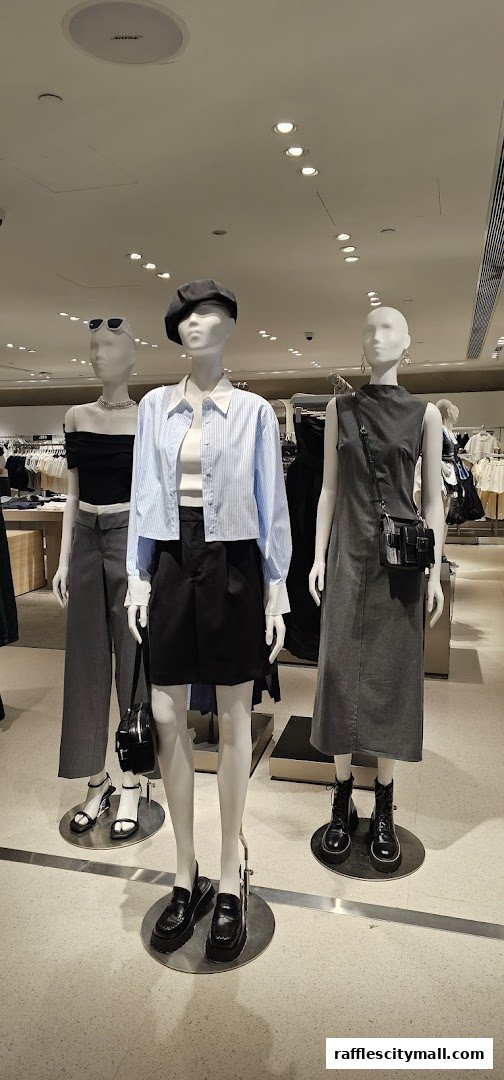 Mannequins display stylish outfits including a striped shirt, skirt, dress, and trousers.