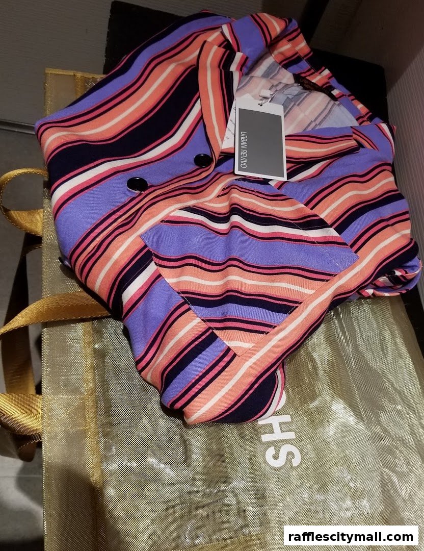 A colorful striped blazer from Urban Revivo is displayed on a golden shopping bag.