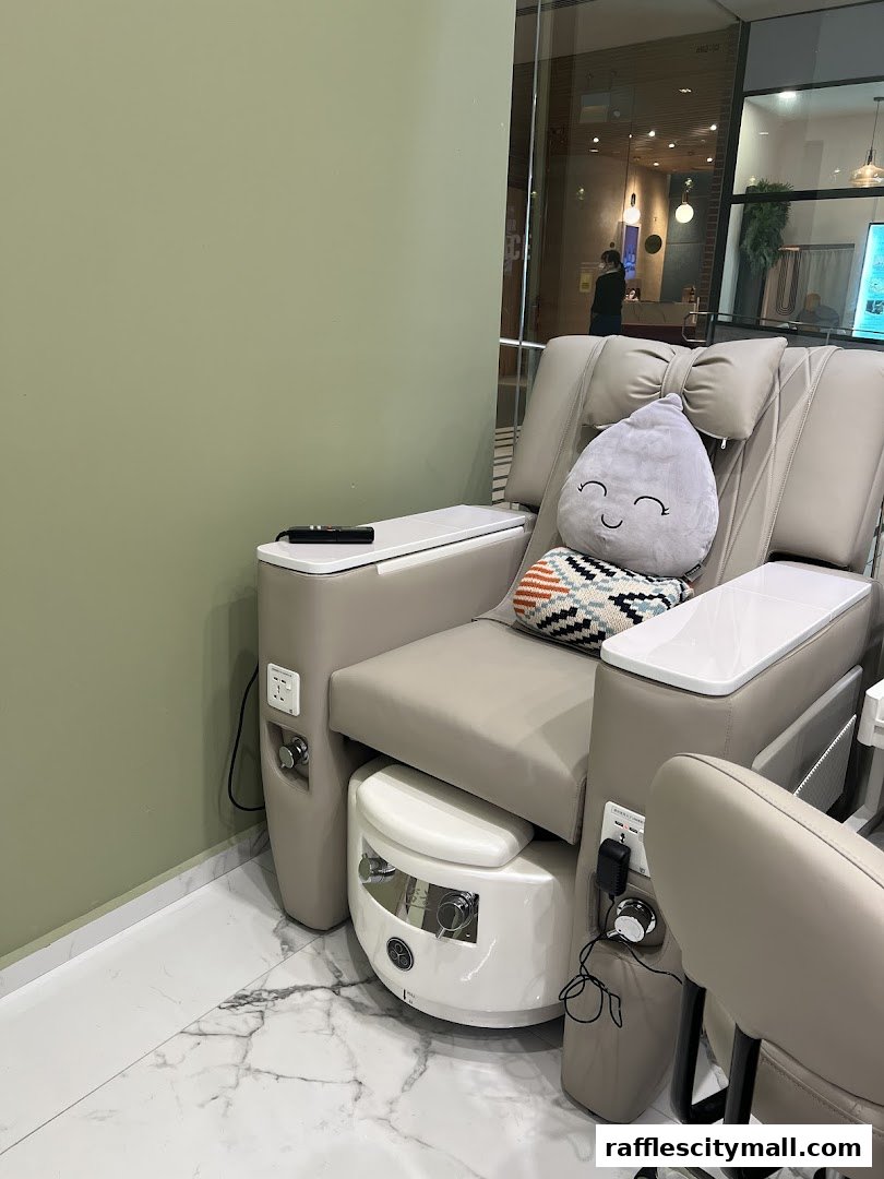 A comfortable pedicure chair with a foot bath and a cute cloud-shaped pillow.