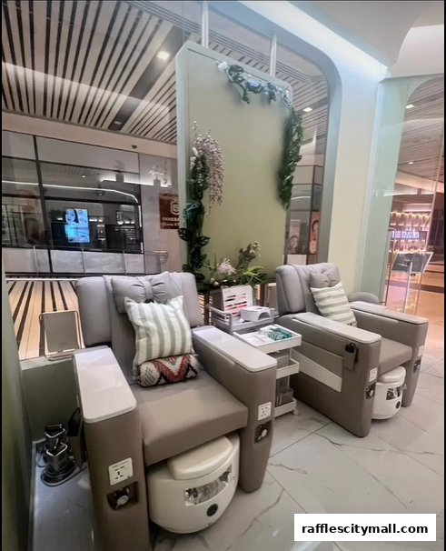 Two comfortable pedicure chairs with foot baths and decorative floral arrangements.