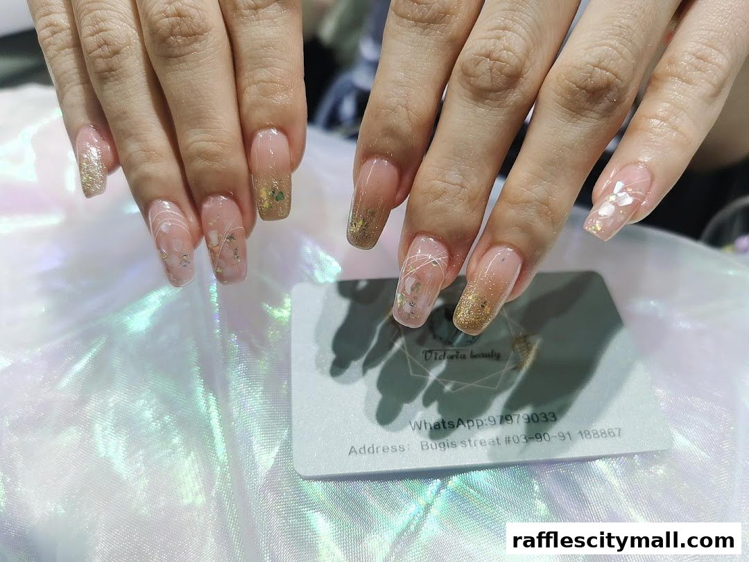 Close-up of beautifully designed nails with glitter and floral accents.