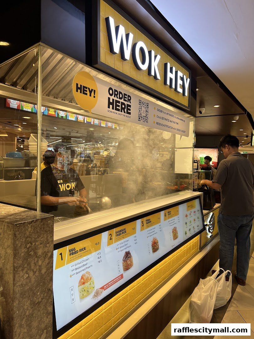 Wok Hey restaurant counter with a digital menu and staff preparing food.