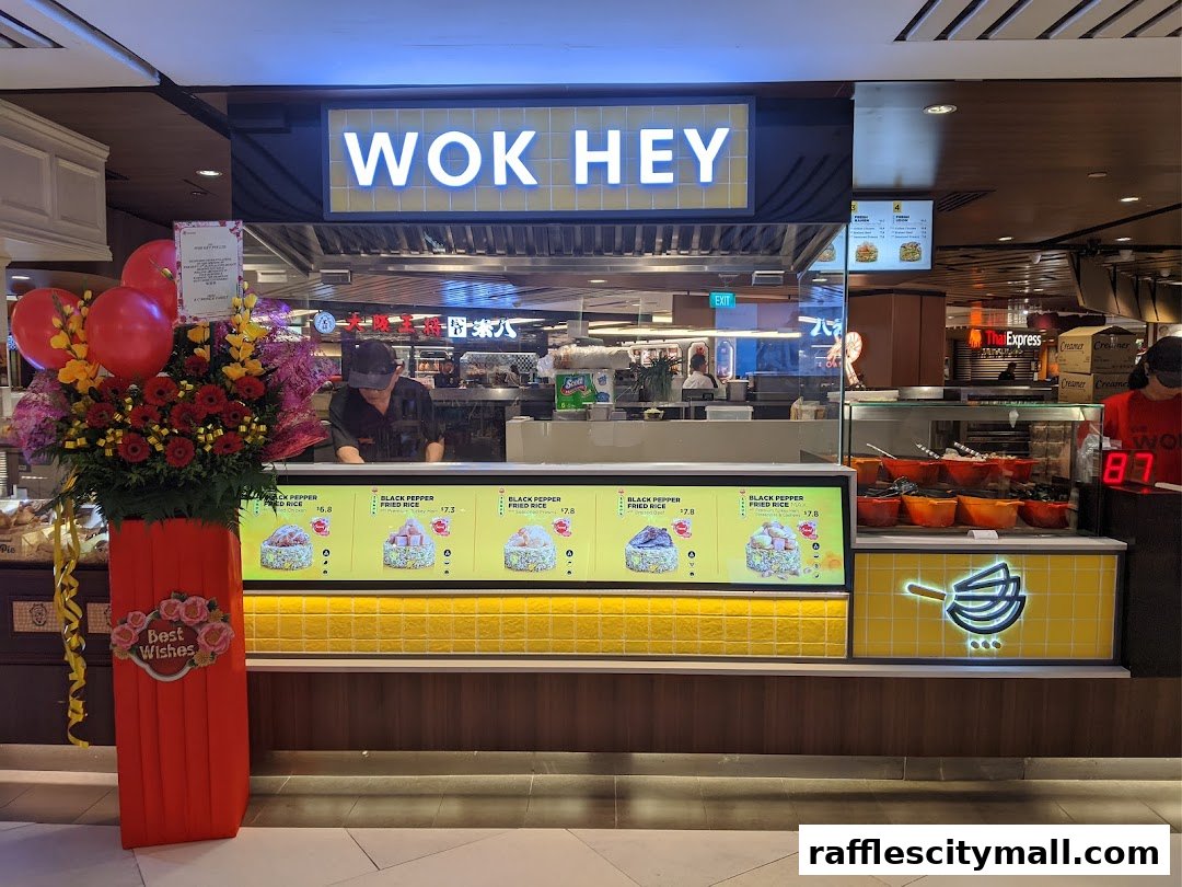 The Wok Hey shop front with a display of fried rice dishes and a floral arrangement.