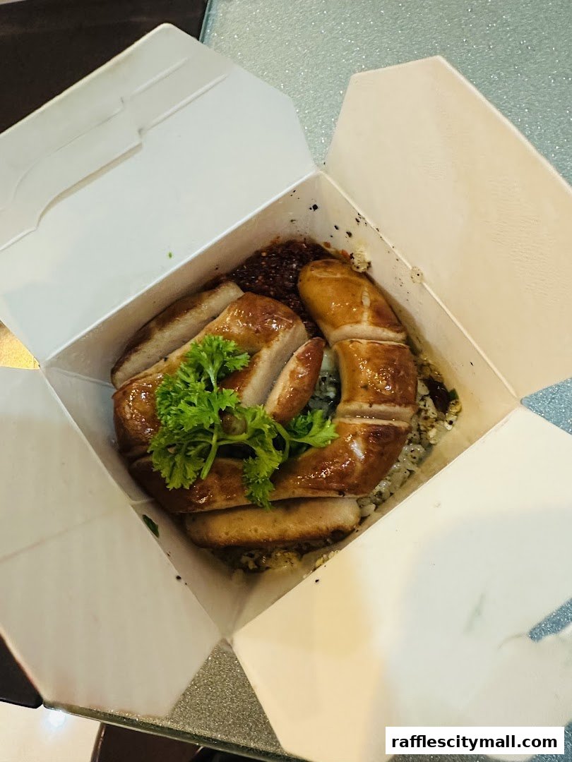 A takeaway box filled with rice, topped with sliced grilled meat and garnished with parsley.