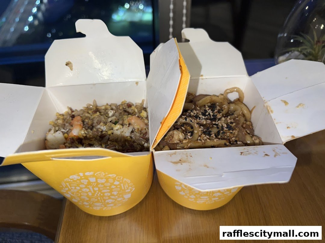 Two open takeaway boxes filled with delicious Asian-inspired dishes, one with fried rice and shrimp, the other with noodles.