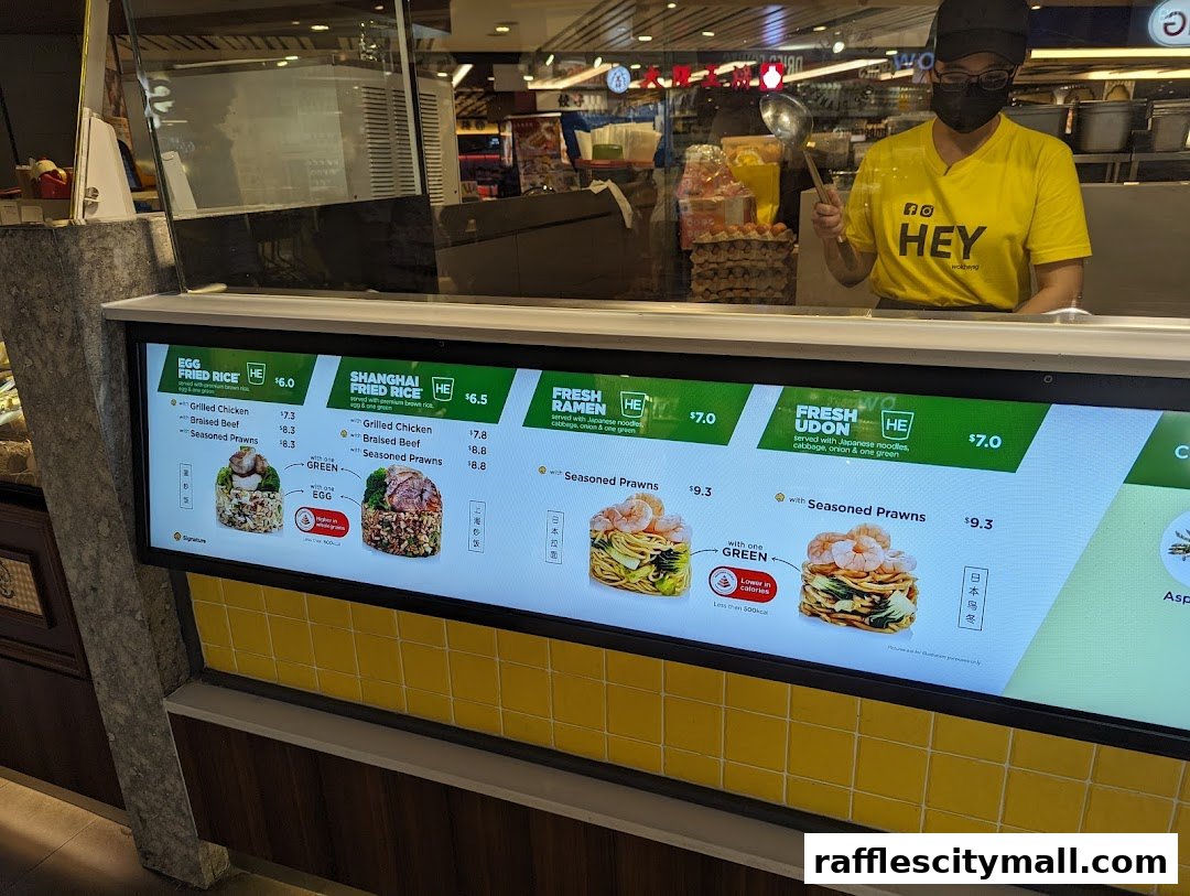 A digital menu board displaying various rice, ramen, and udon dishes with prices and ingredients.
