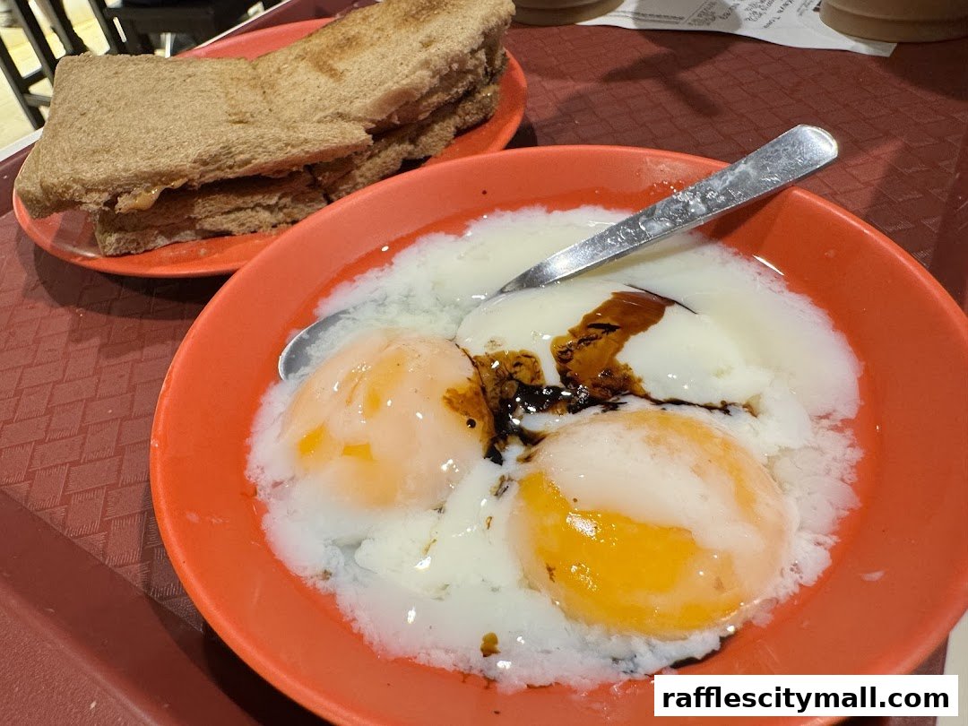 A close-up of soft-boiled eggs with soy sauce and toast at Ya Kun Kaya Toast.