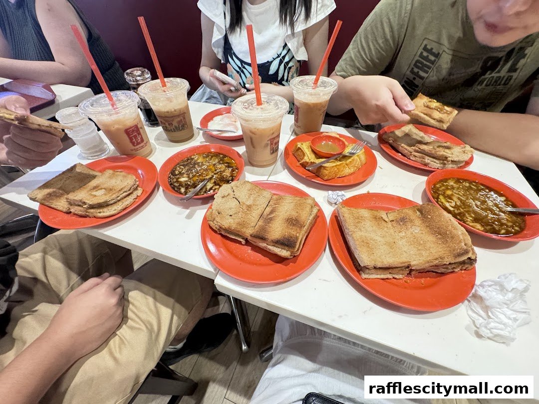 A table laden with Ya Kun Kaya Toast's signature dishes, including kaya toast, soft-boiled eggs, and iced beverages.