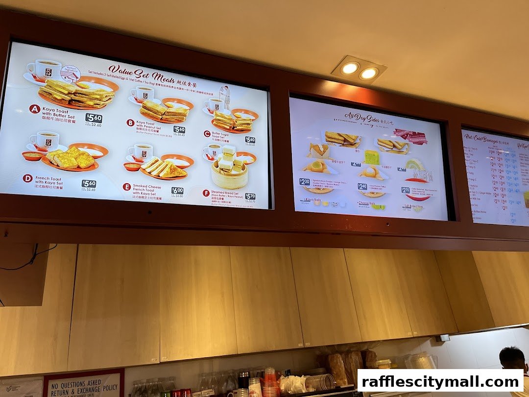 Digital menu boards displaying value set meals, all-day sides, and beverages at Ya Kun Kaya Toast.