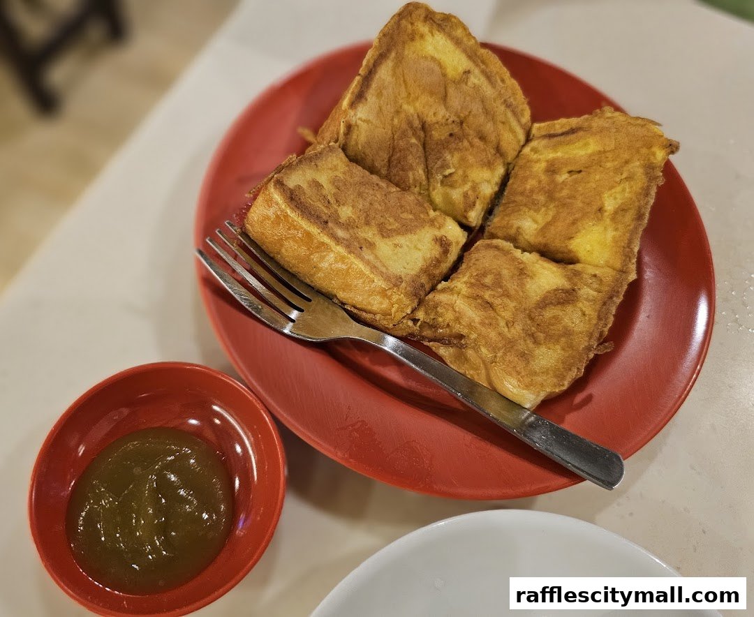 A plate of golden-brown French toast served with a small bowl of green jam and a fork.